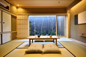 um quarto com uma mesa e uma grande janela em Miun Kinkaku-ji em Quioto