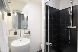 un baño con lavabo y ducha en L'Atelier Nantais by Cocoonr, en Nantes 8 fotos más