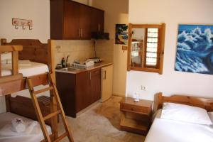 a small room with two bunk beds and a kitchen at Patroudis House in Skala Rachoniou