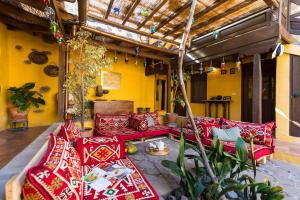 un patio con sofás rojos y una mesa en Bohemian Hideaway Finca - 2 unique houses with shared pool, en Santa Lucía