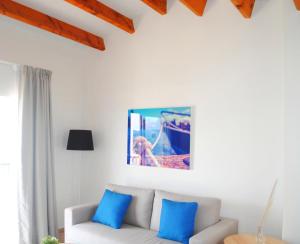a living room with a white couch and blue pillows at TRH Tirant Playa in Fornells