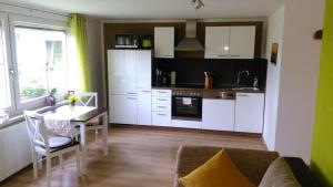 ein Wohnzimmer mit einem Tisch und einer Küche in der Unterkunft Ferienoase Lilienstein in Rathmannsdorf