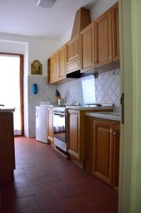 a kitchen with wooden cabinets and a tile floor at Le ginestre in San Severino Marche