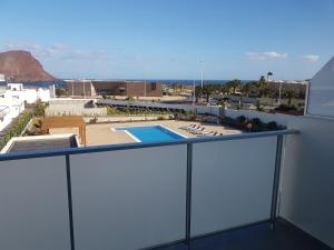 a balcony with a view of a swimming pool at Vista Montaña Roja Medano in El Médano