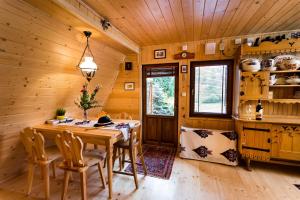 a wooden dining room with a table and chairs at Góralski domek z kominkiem, wygodny, ciepły, zwierzaki mile widziane, ogrodzony in Łopuszna +13 photos