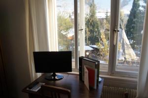 a computer monitor sitting on a desk in front of a window at Villa Donkey BnB in Degersheim