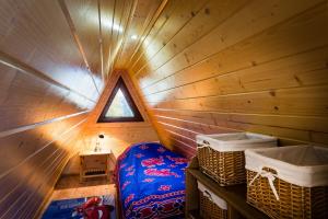 a small room with a bed in a wooden cabin at Góralski domek z kominkiem, wygodny, ciepły, zwierzaki mile widziane, ogrodzony in Łopuszna