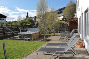 a group of picnic tables and benches on a patio at Gasthof Hirschen in Sibratsgfäll