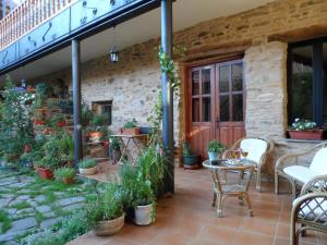 un patio con mesa, sillas y plantas en La Casa del Filandón- HOTEL RURAL, en Quintanilla de Somoza