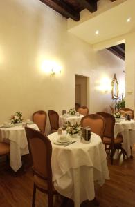 un comedor con mesas y sillas con mantel blanco en Hotel Locanda Canal, en Venecia