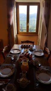 a table with plates and dishes on it with a window at La Grange Fleurie in Tramayes