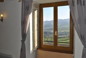 a window with a view of a mountain at La Grange Fleurie in Tramayes