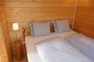 DegersheimにあるVilla Donkey Chaletの木造キャビン内のベッドルーム1室(ベッド2台付)