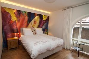 a bedroom with a large painting on the wall at B&B In de zevende hemel in Reijmerstok