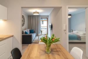 a kitchen and living room with a table and a living room at Apartamenty Pod Gubałówką in Zakopane