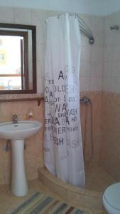 a bathroom with a shower curtain and a sink at Kortiri Studios in Agios Nikolaos