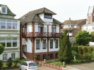 a house with a car parked in front of it at Hotel Villa Caldera in Cuxhaven