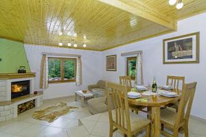 a living room with a table and a fireplace at Chalets Bogo & Neno in Ledenice