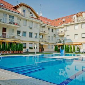 einem großen Pool vor einem Gebäude in der Unterkunft Relax Beach Apartman in Hajdúszoboszló