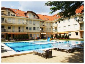 a swimming pool in front of a large building at Relax Beach Apartman in Hajdúszoboszló
