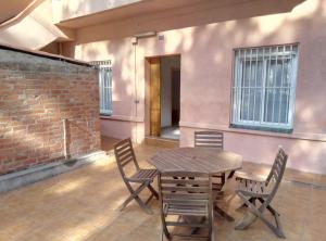 einen Holztisch und Stühle auf einer Terrasse in der Unterkunft Casa Carmen Barcelona in El Prat de Llobregat