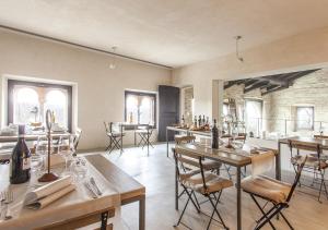a dining room with tables and chairs and windows at Castello di Gabiano in Gabiano