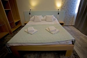 a bed with two towels on top of it at Motelik Grosar Gorlice in Gorlice