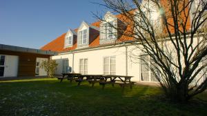 einem Picknicktisch vor einem weißen Gebäude in der Unterkunft Hotel Aarslev Kro in Brabrand