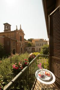 une table avec une assiette de nourriture sur un balcon dans l'établissement Monza City Rooms & Studios, à Monza