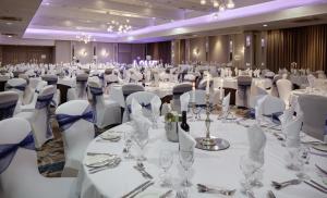 a large banquet hall with white tables and chairs at Glasgow Grosvenor Hotel in Glasgow