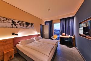 a bedroom with a large bed and a large window at BEST WESTERN Hotel The K Unterföhring in Munich