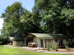 a tent with people sitting in it in a field at Atmospheric tent lodge with dishwasher in Twente in Buurse