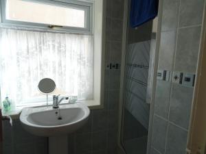 a bathroom with a sink and a window and a shower at Glendowie Hotel in Blackpool