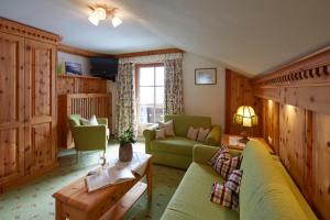 ein Wohnzimmer mit einem grünen Sofa und Stühlen in der Unterkunft Gintherhof in Reutte