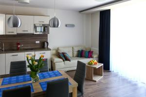 a kitchen and a living room with a dining table at Apartamenty w Marina Jastrzębia Góra in Jastrzębia Góra