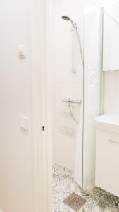 a white bathroom with a shower and a sink at Vironkatu 3 in Helsinki