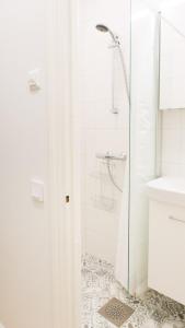 a white bathroom with a shower and a sink at Vironkatu 3 in Helsinki