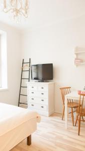 a living room with a tv on a white dresser at Vironkatu 3 in Helsinki