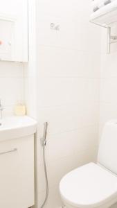 a white bathroom with a toilet and a sink at Vironkatu 3 in Helsinki +3 photos