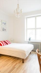 a white bedroom with a large bed and a chandelier at Vironkatu 3 in Helsinki