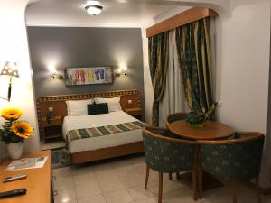 um quarto de hotel com uma cama e uma mesa em Real Caparica Hotel em Costa da Caparica