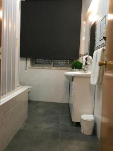 a bathroom with a sink and a tub and a toilet at Real Caparica Hotel in Costa da Caparica