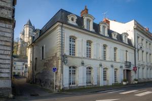 duży biały budynek po stronie ulicy w obiekcie Le Patio & Spa w mieście Saumur