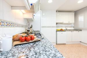 サンタ・スサナにあるEuropa Square Apartmentのキッチン(カウンター付、カッティングボードにトマトをかける)