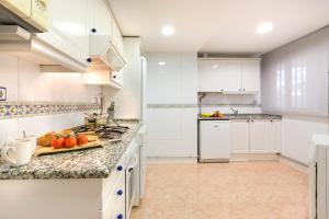 kuchnia z białymi szafkami i blatem w obiekcie Europa Square Apartment w Santa Susanna