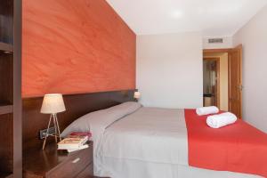 a bedroom with a bed with a red and white blanket at Europa Square Apartment in Santa Susanna +10 photos