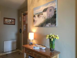 a room with a table with a vase of flowers on it at B2 Waterfoot Apartment in Newcastle