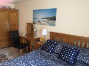 a bedroom with a bed and a desk with a chair at B2 Waterfoot Apartment in Newcastle