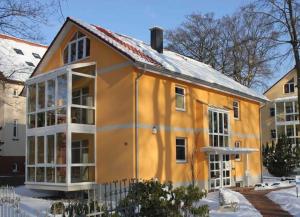 Ostseepark Waterfront_ Galeone 43 في هيرينجسدورف: منزل برتقالي مع نوافذ بيضاء في الثلج