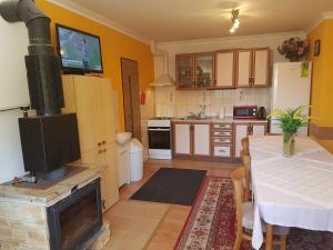 uma cozinha com uma mesa e um fogão num quarto em Apart-Bungalovy Gitka em Mlynčeky